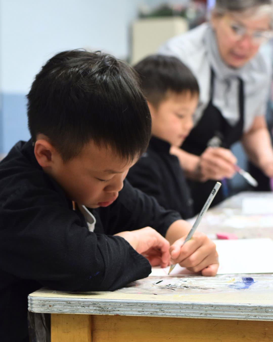 Art instructor helping campers draw
