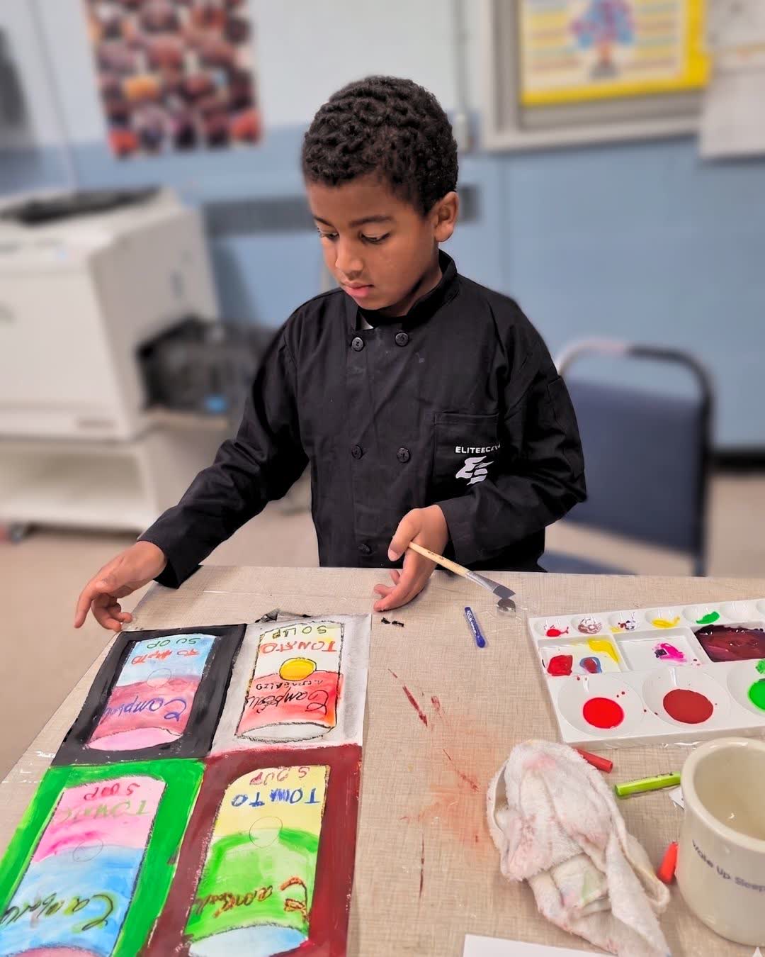 Camper painting soup cans at art camp