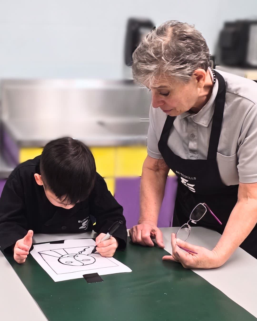 Art teacher working with a student