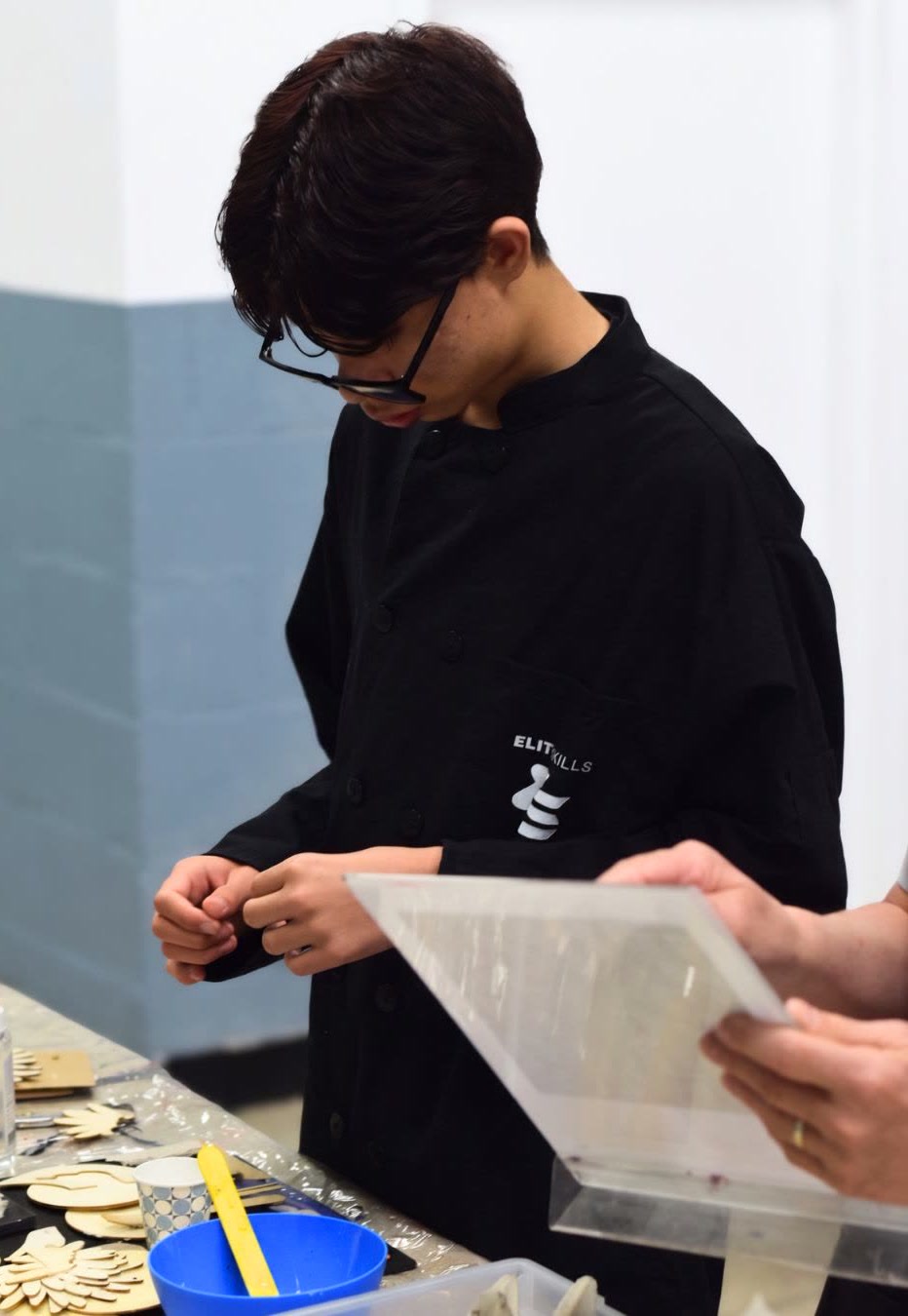 An Elite Skills art instructor and a student handling a print together
