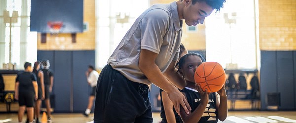 Elite Skills coach guiding a young player's shot at camp